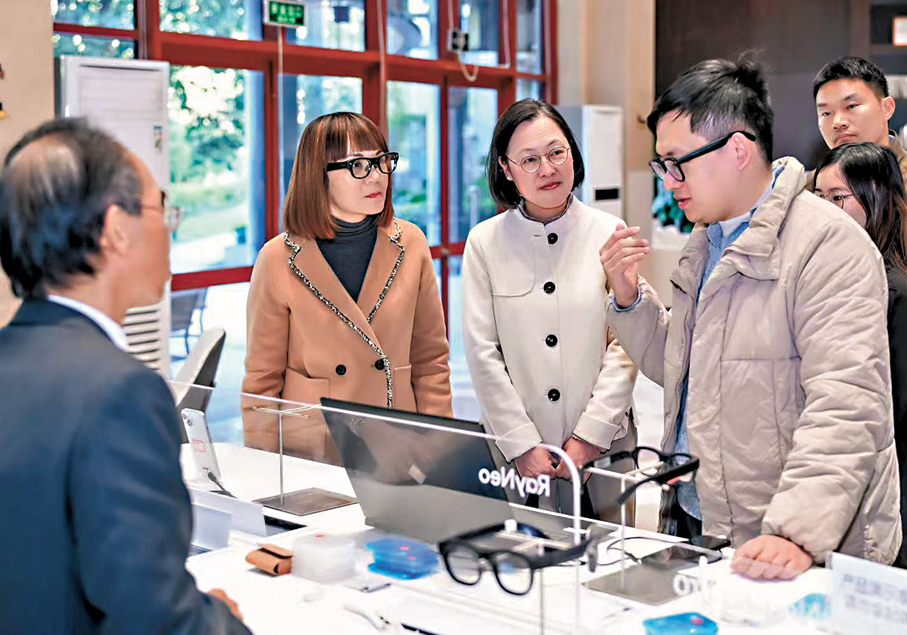 ●專員陳潔玲（左二）和助理專員李矜持（左三）1月7日參觀一家專門研發和生產納入全彩MicroLED透明顯示的AI眼鏡的企業。 Fb圖片