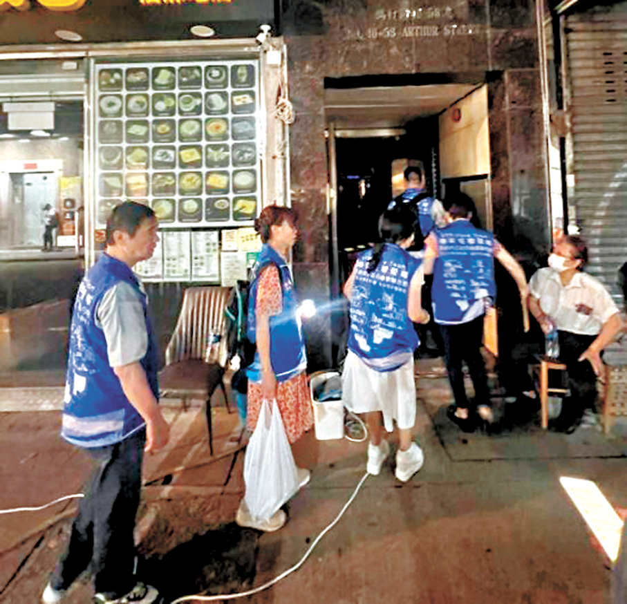 ●隊員帶備臨時照明裝備及樽裝水，進入尚未恢復水電供應的大廈協助居民。 作者供圖