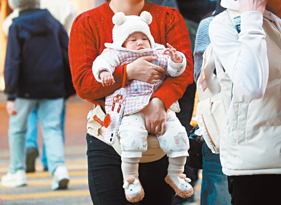 細心呵護●小寶寶躺在家人懷裏，感受無限溫暖。香港文匯報記者郭木又  攝