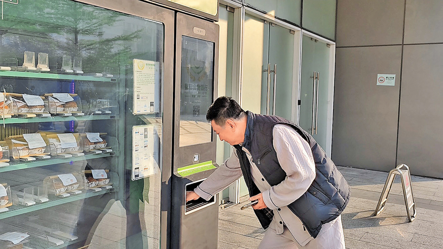 ●劉叔正在櫃機上領取食物。香港文匯報記者胡永愛 攝