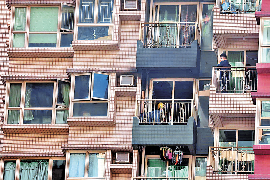 ●消防在起火單位內調查，單位露台及外牆熏黑，並波及樓上單位。 香港文匯報記者劉友光  攝