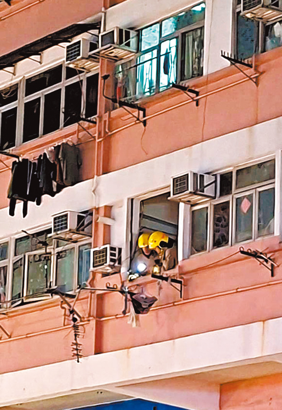 ●消防員登樓調查，肇事單位窗口整幅鋁窗脫落。 香港文匯報記者鄧偉明  攝