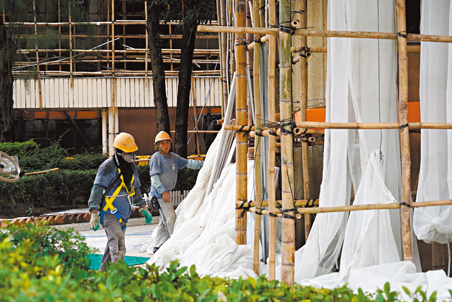 ●宏福苑火災後，本港揭發多間建築商採取不合規物料，保聯預料建築全險保費將有很大機會調整。圖為工人早前拆除棚網。 資料圖片