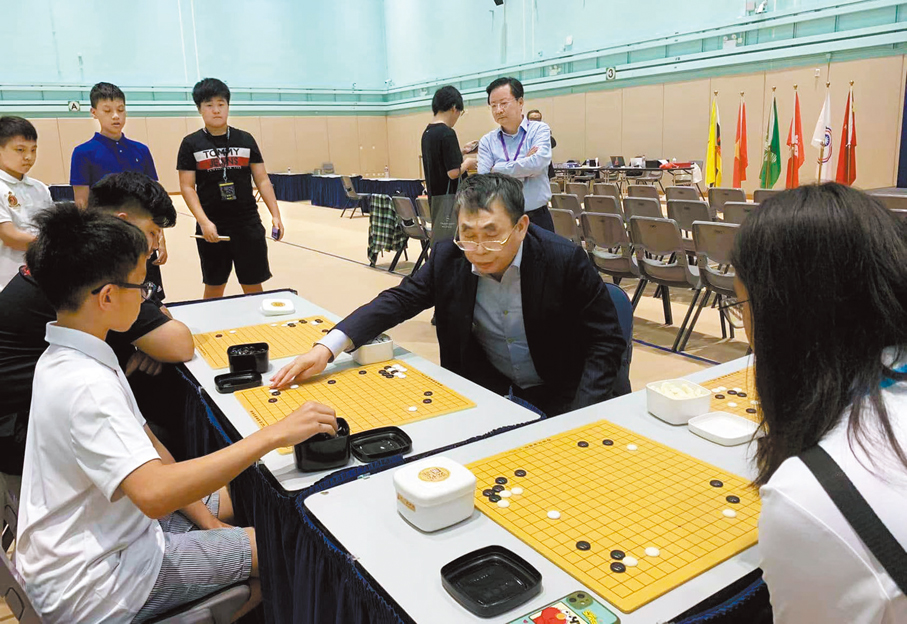 ●來港出席「香港國際大學生圍棋公開賽」的聶衛平指導年輕人對弈。 資料圖片