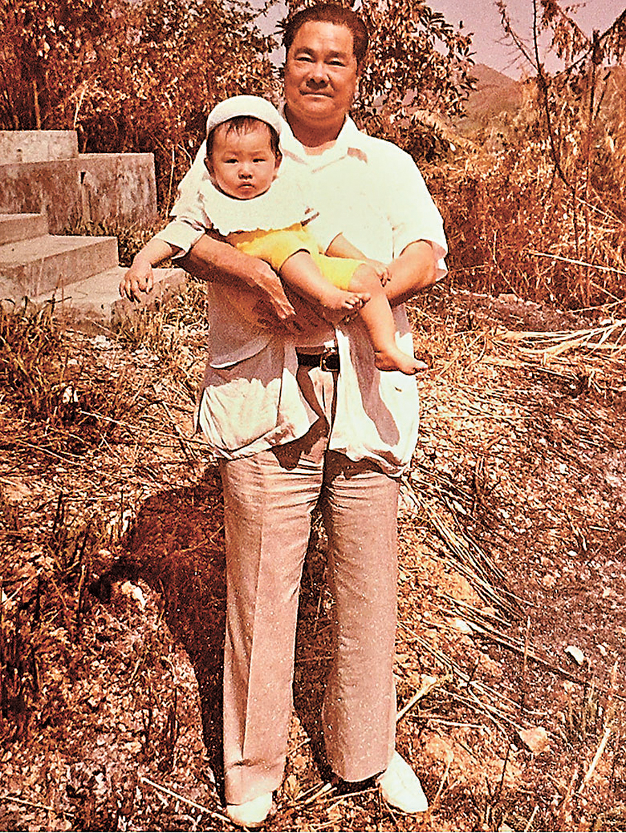 ●父親抱着長孫前往祭祖，一臉慈祥且驕傲的笑容。 作者供圖