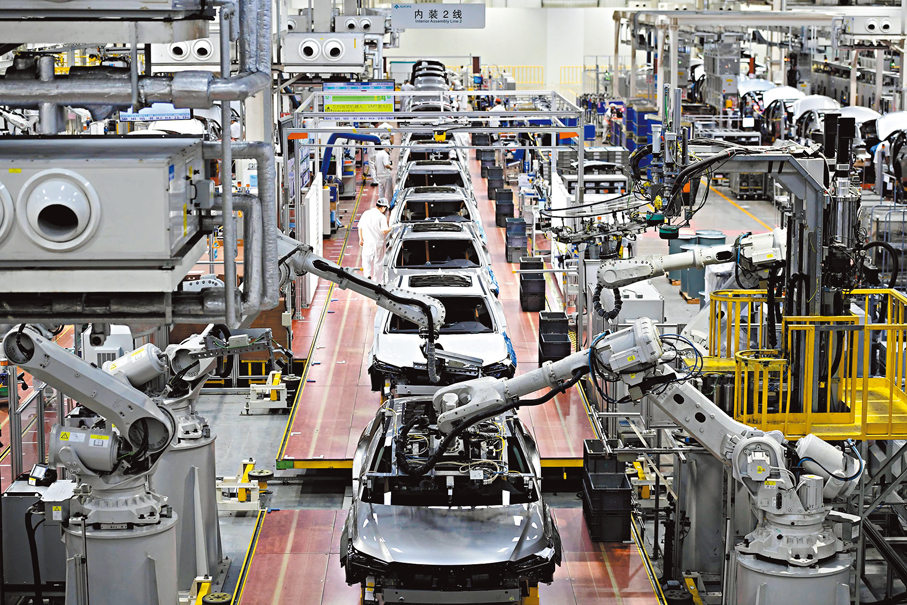 ●2035年，廣州力爭建成萬億級「智車之城」。圖為在廣汽埃安智能生態工廠總裝車間，機械臂在為汽車安裝擋風玻璃。  資料圖片
