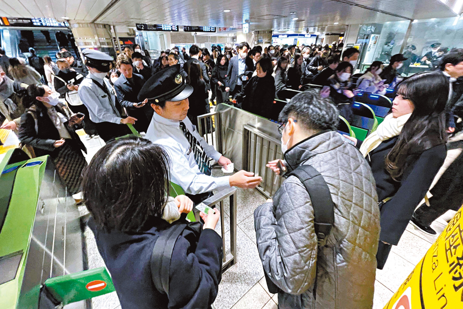 ●東京新橋站出現混亂，車站職員向乘客講解情況。 法新社