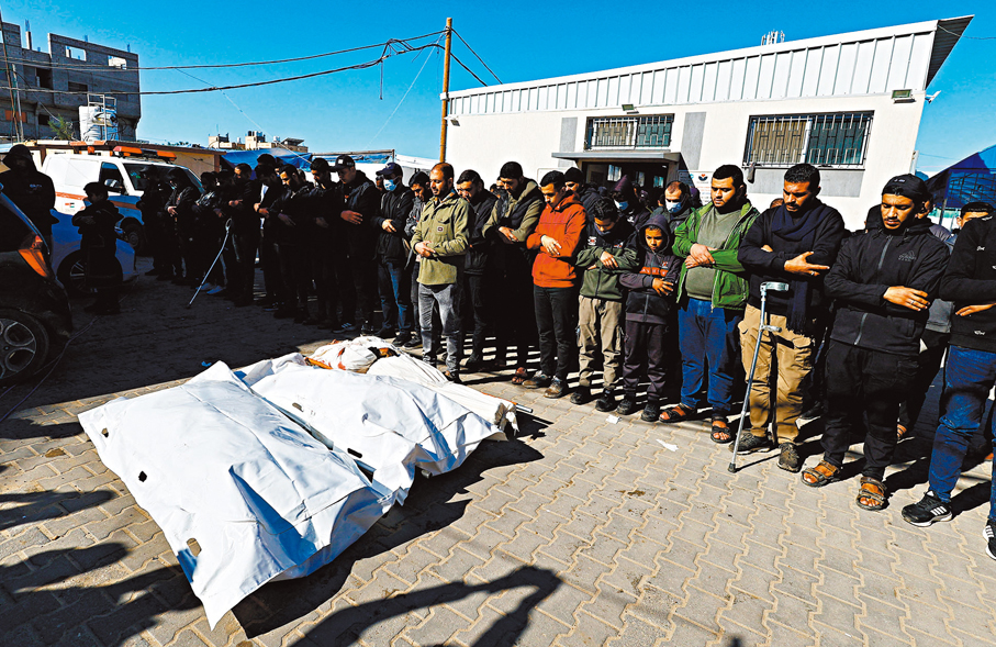 ●加沙代爾拜拉赫市民悼念空襲喪生人士。 路透社