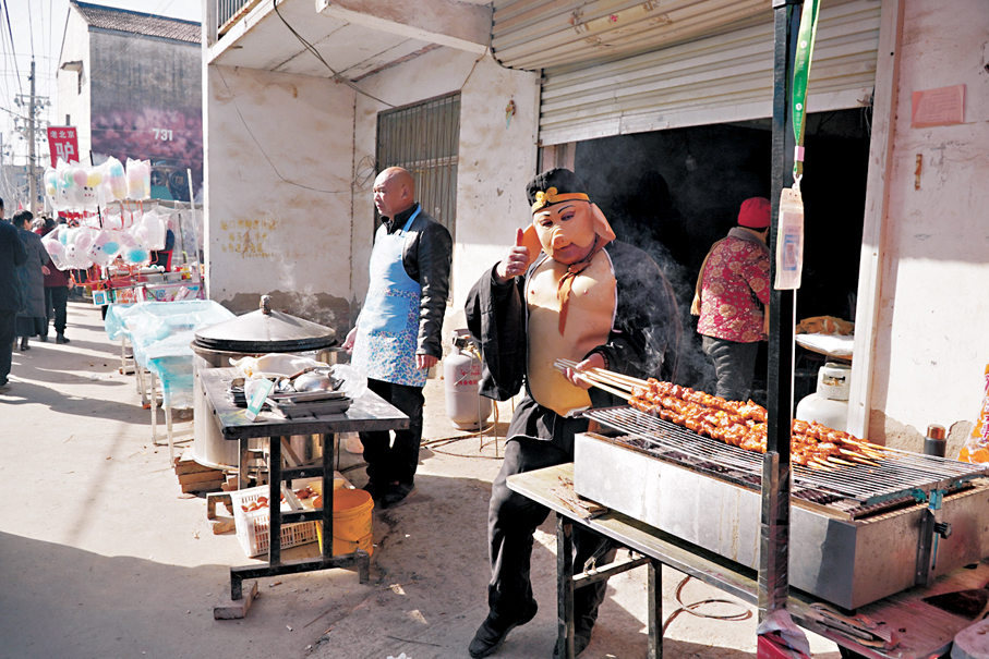 ●吳營村200多個攤位沿街道一字排開，比趕大集還要熱鬧。圖為村裏賣烤串的「八戒」。