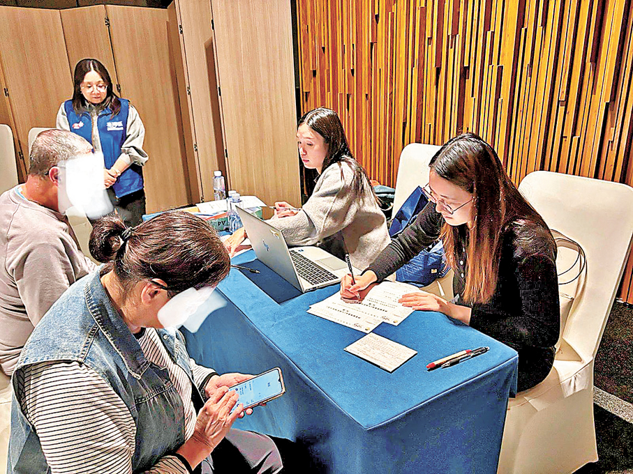 ●關愛隊在酒店設服務站，即場協助居民填寫援助申請表。 作者供圖