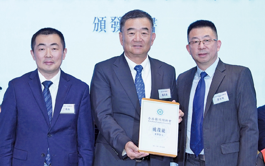 ●胡啟明（右一）、丁四海（左一）為姚茂龍頒發榮譽會長聘書。