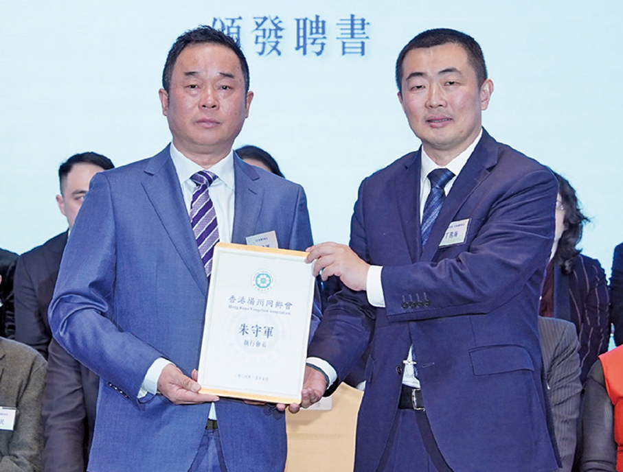 ●丁四海（右）為朱守軍頒發執行會長聘書。