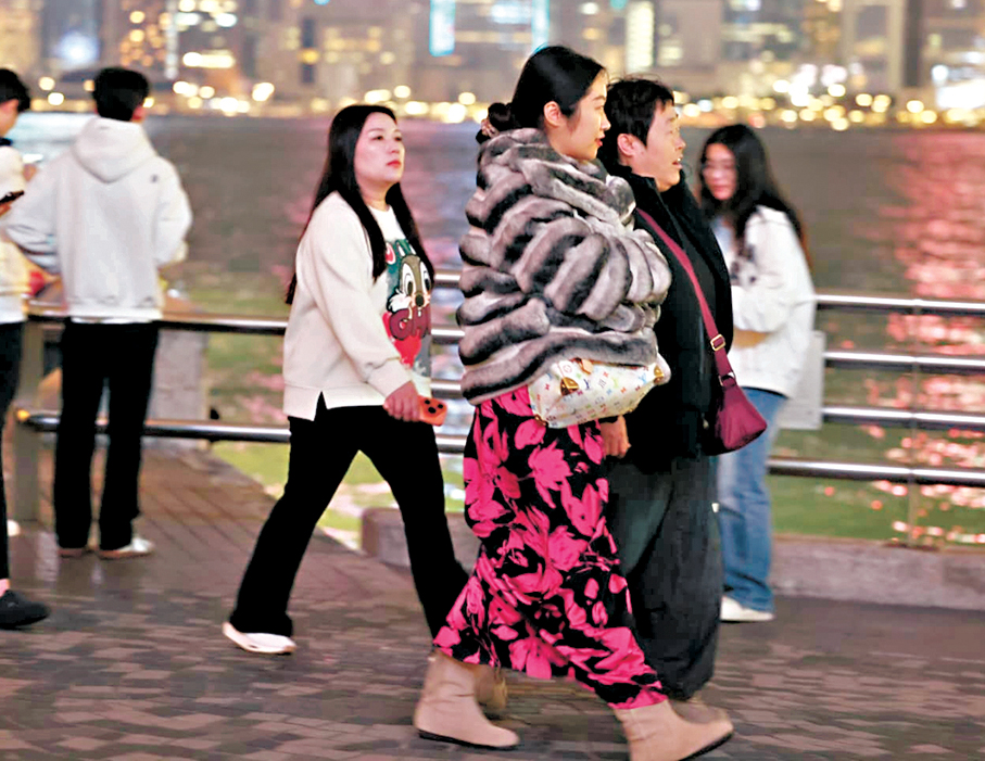 ●昨晚寒冷天氣警告生效下，市民外出明顯多穿了衣服禦寒。 香港文匯報記者鄧偉明  攝