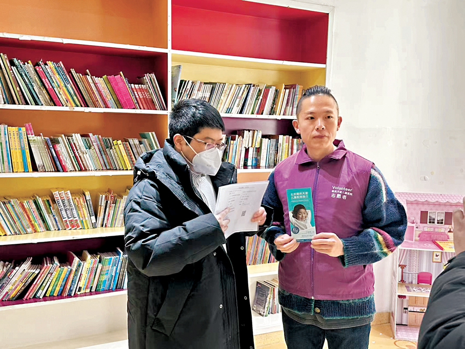 ●蔡先生手持捐款憑證，與工作人員合影留念。香港文匯報記者蘇雨潤  攝