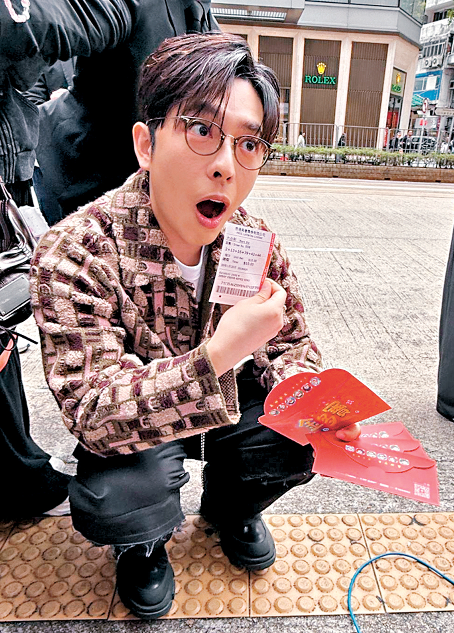 ●呂爵安展示利是內有六合彩彩票。 香港文匯報記者阿祖 攝