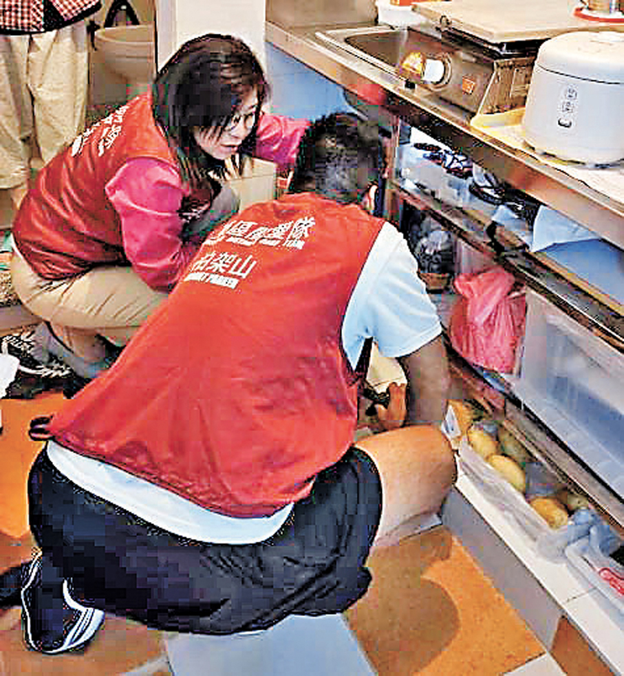 ●關愛隊義工協助長者修理廚櫃。 作者供圖