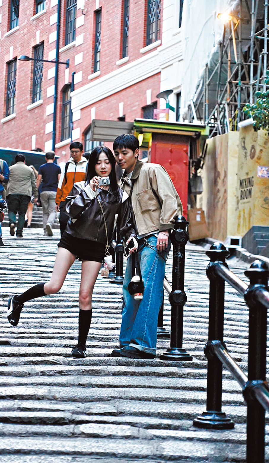 ●年輕人手持復古CCD數碼相機，在石板街上拍照打卡，記錄他們的共同回憶。 香港文匯報記者曾興偉  攝 