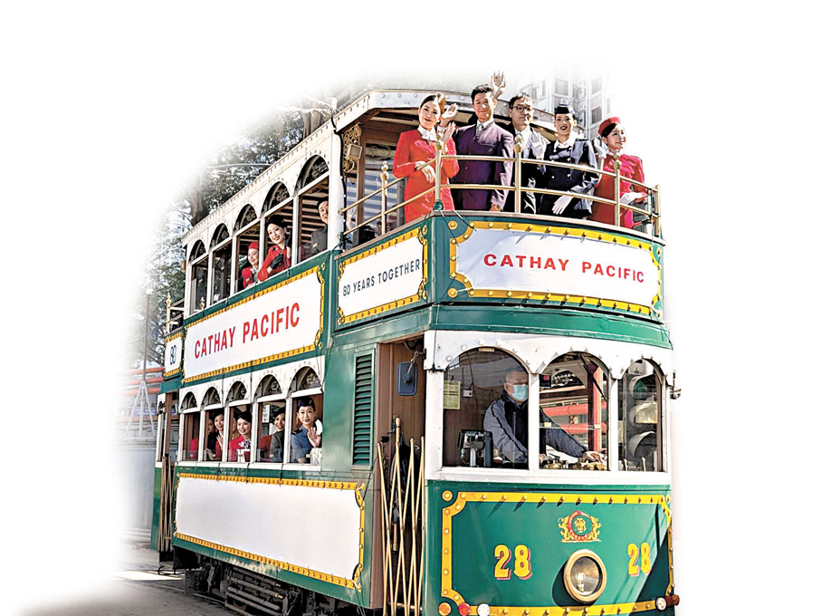 ●國泰機艙服務員身穿多款歷代經典制服，於懷舊電車上向市民熱情打招呼。 香港文匯報記者崔瀅  攝