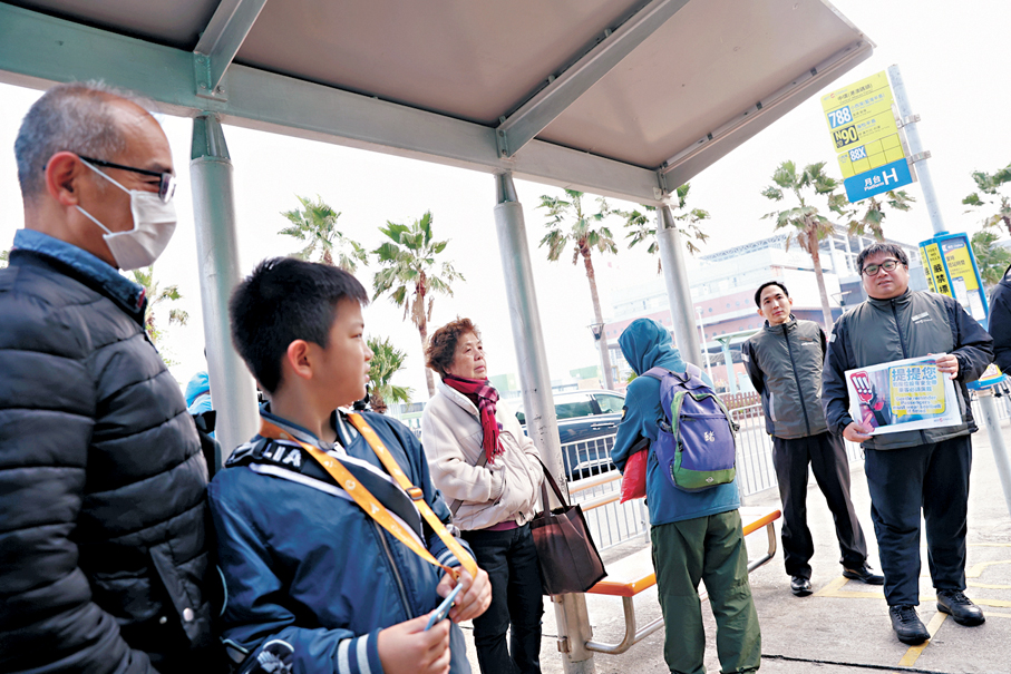 ●城巴派員在巴士站向乘客宣傳佩戴安全帶。  香港文匯報記者萬霜靈  攝