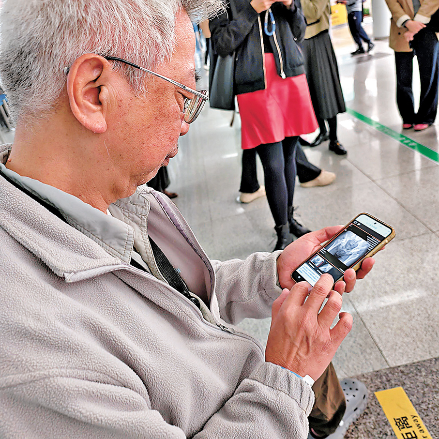 ●在香港大學深圳醫院，香港居民容先生正查看自己在該院拍攝的影像片。香港文匯報記者李望賢  攝