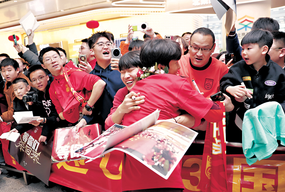●國足球員蒯紀聞（前）與球迷擁抱。  新華社