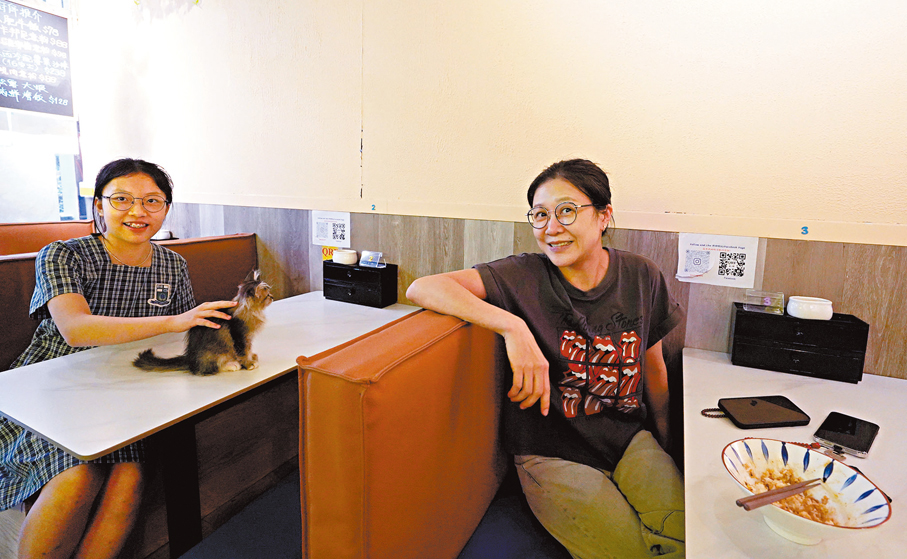 ●翁小姐（右）表示，自己愛貓卻無力飼養，餐廳的貓剛好填補心中遺憾。旁為她女兒。 香港文匯報記者曾興偉 攝