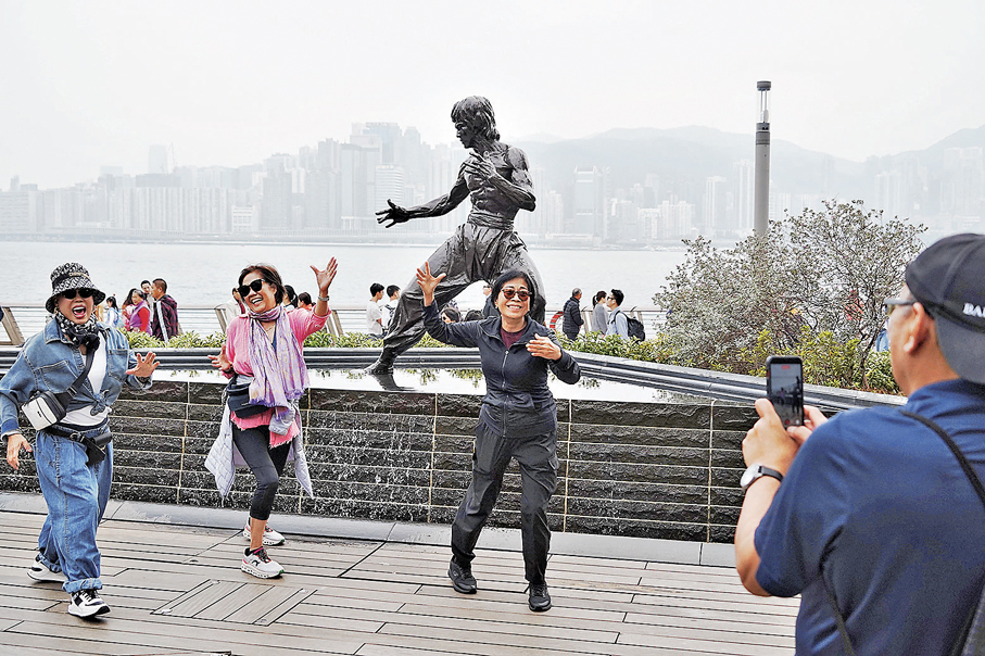 姊妹特地來李小龍像下打卡，共度歡樂時光。香港文匯報記者曾興偉  攝