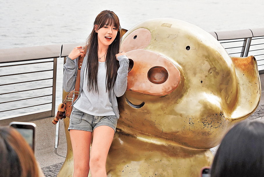 少女與麥兜合照，麥兜古靈精怪，少女靚麗活潑。青春氣息洋溢星光大道。 香港文匯報記者曾興偉 攝