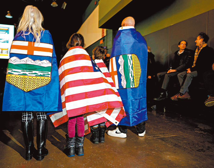 ●艾伯塔省謀求獨立的民眾在集會上披起美國國旗。 彭博社