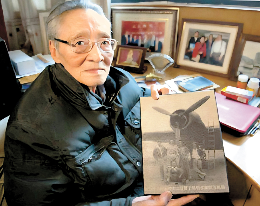 ●龍啟明拿着當年的照片，感慨萬千！ 作者供圖