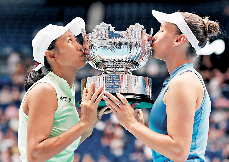 ●張帥（左）和梅爾滕斯親吻獎盃。  新華社