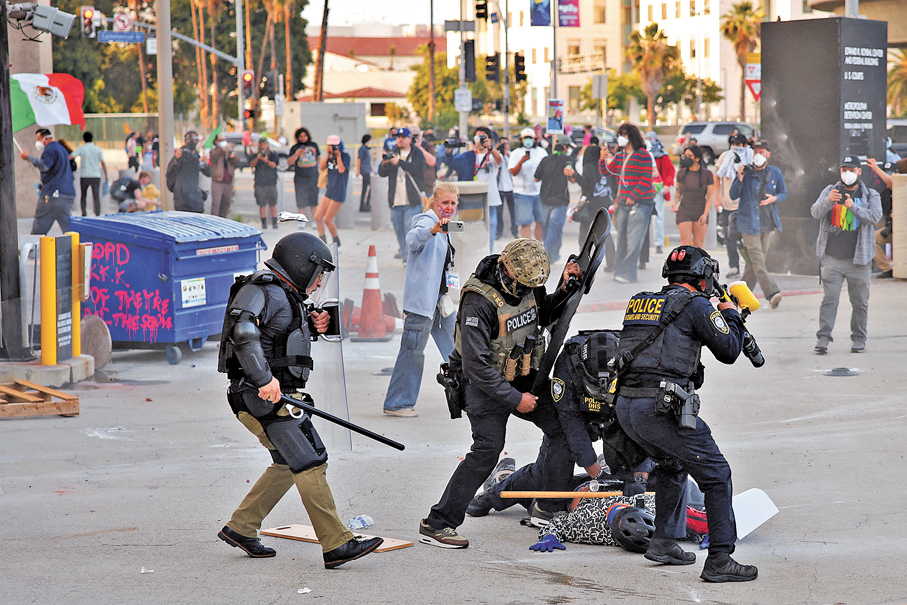 ●美國國內不確定性日益加劇之際，愈來愈多美國人積極申請第二本護照，將雙重國籍視為分散地緣政治風險、降低生活成本的備選方案。圖為美國警方在洛杉磯市中心，拘捕一名試圖堵塞聯邦大樓車庫入口的示威者。 資料圖片