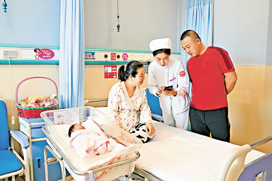 ●從各地實踐看，鼓勵生育正逐步從單一現金補貼，轉向「資金補貼+服務支持」並軌推進。圖為早前內蒙古呼和浩特市婦幼保健院內，護士幫助新生兒家庭申請育兒補貼。資料圖片