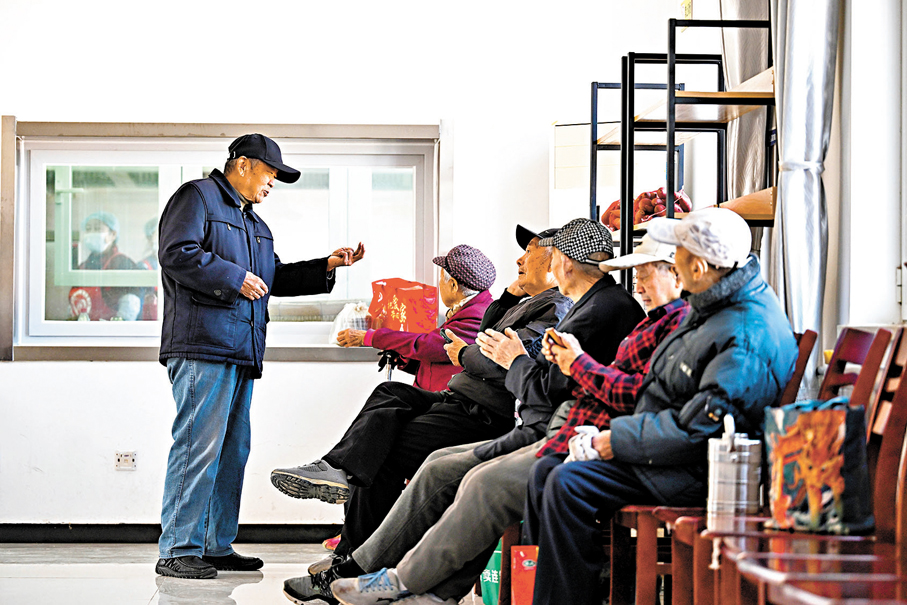 ●早前在天津市濱海新區古林街道欣欣里社區互助食堂，老人們在等候打飯時聊天。資料圖片