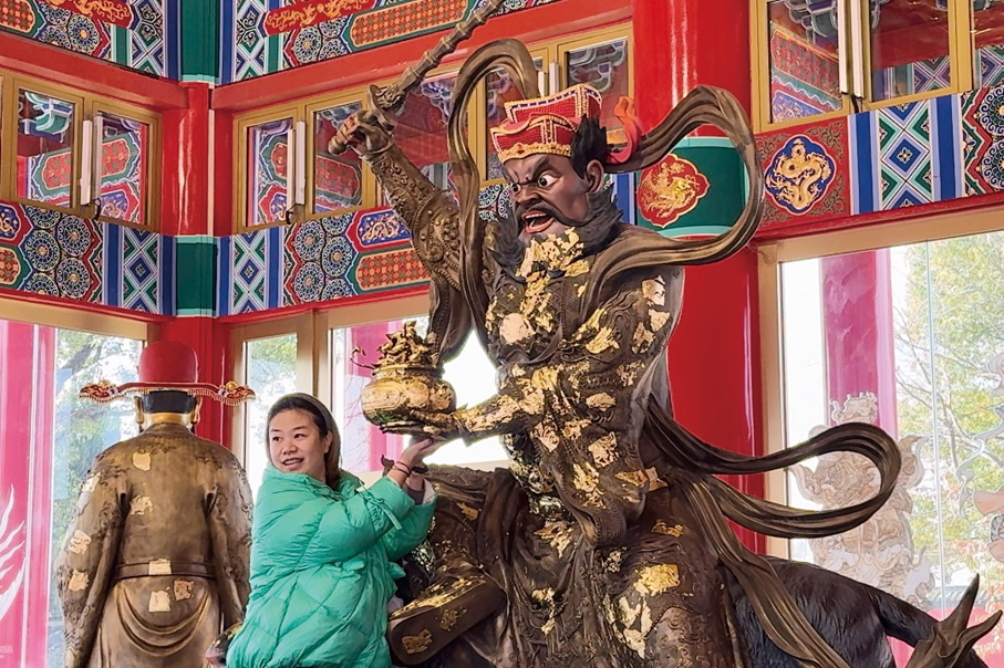 ●信眾在財神宮內的五路財神身上「貼金箔」，以祈求財源廣進。