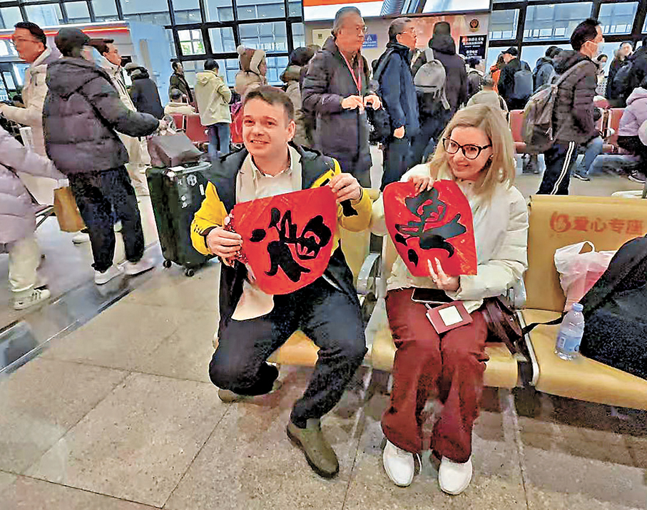 ●北京西站工作人員為海外旅客送上福字。 香港文匯報記者郭瀚林 攝