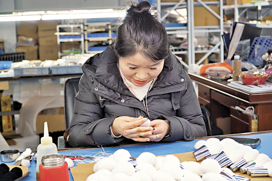 ●王新芝的手就是尺，一捏一比就能給毛頭定型。 香港文匯報記者劉蕊  攝