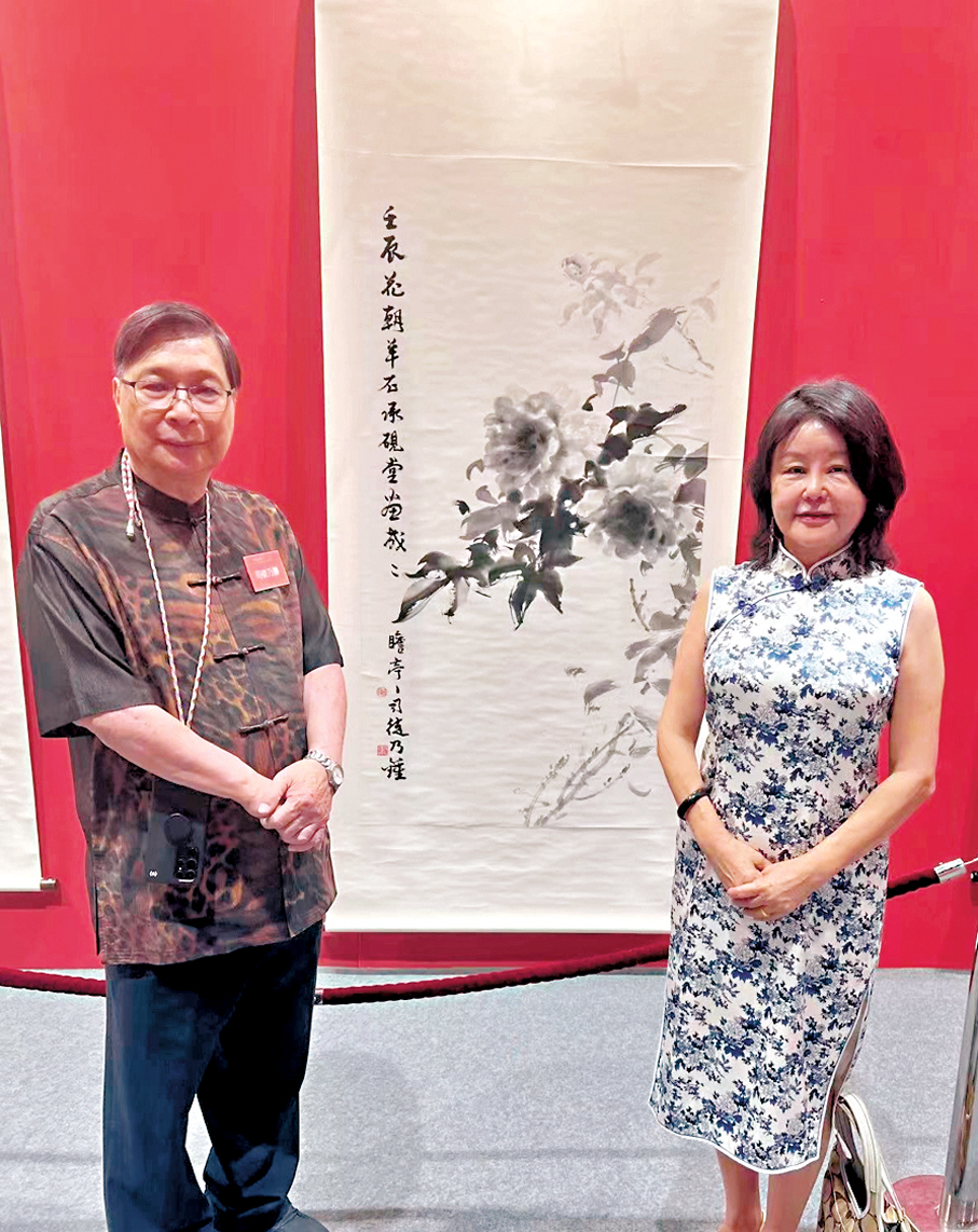 ●富貴猶餘翰墨香，司徒乃鍾與作者立於水墨牡丹前合照。 作者供圖