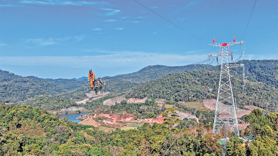 ●5日，施工人員在輸電導線跨國連通處作業。 新華社