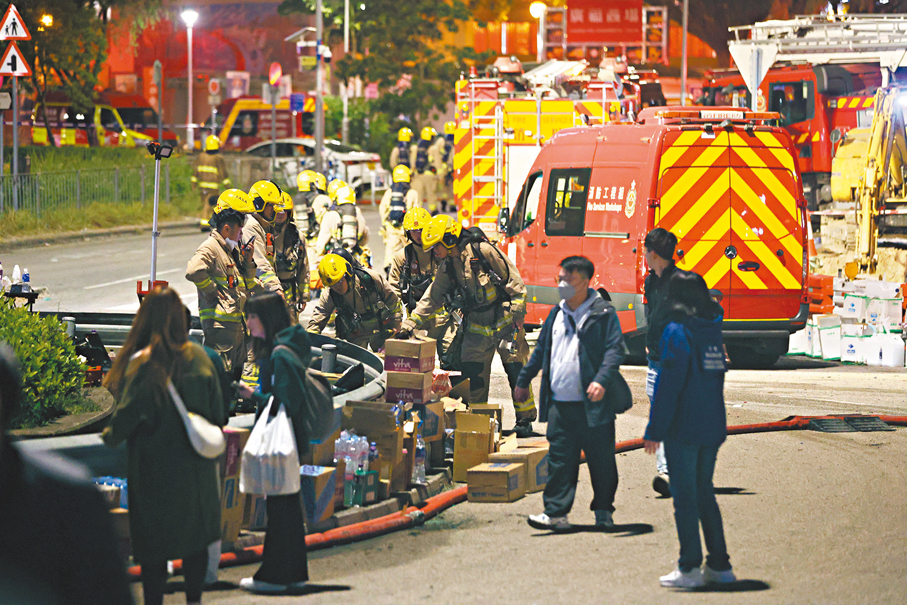 ●市民在火災翌日晚上向通宵撲救火災的消防員送上物資。 資料圖片