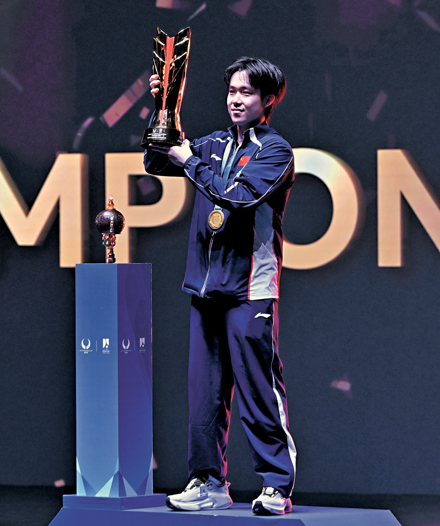 ●王楚欽在頒獎儀式上舉起獎盃。  新華社