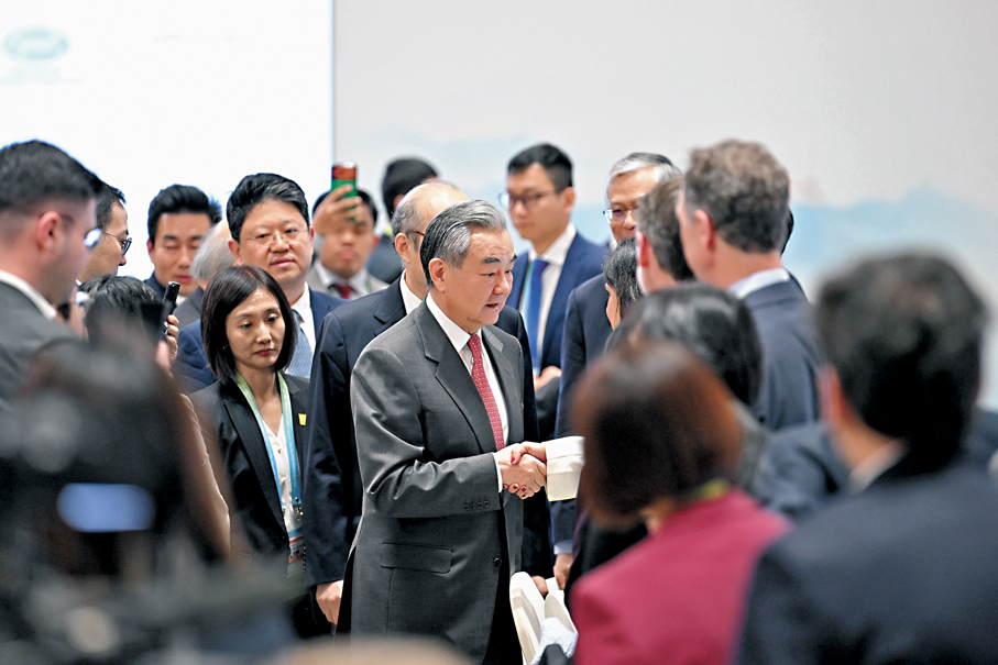 ●開幕式後，王毅和與會嘉賓交談。  中新社