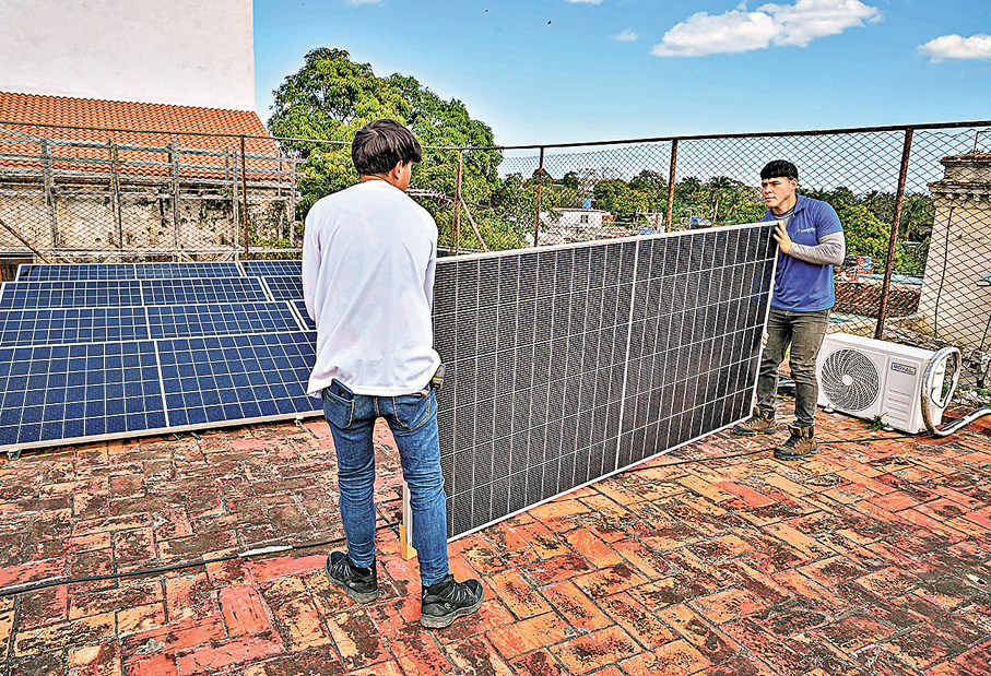 ●古巴民眾安裝太陽能板「自救」。   法新社