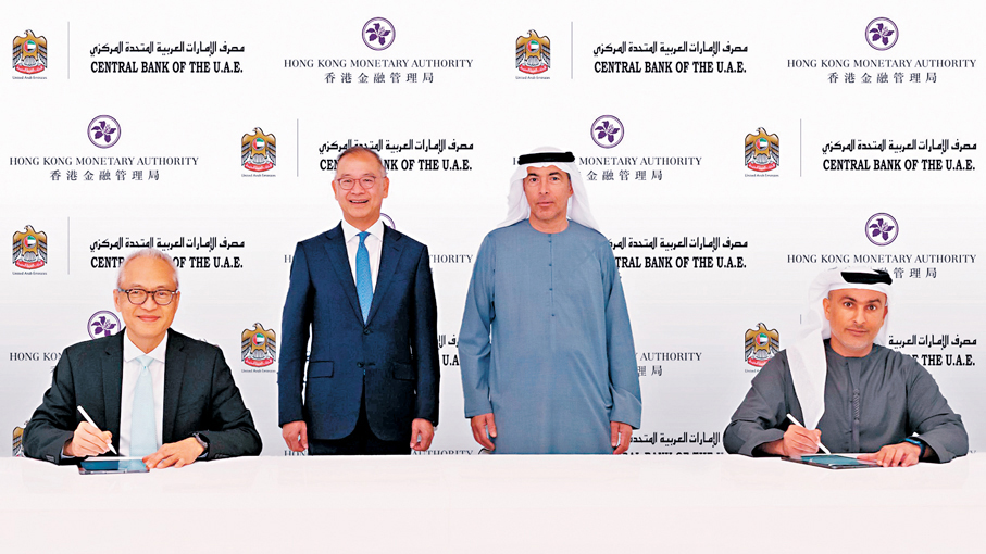 ●在阿聯酋央行行長H.E. Khaled Mohamed Balama（右二）與金管局總裁余偉文 （左二）的見證下，阿聯酋央行與金管局簽署交換債務工具中央結算系統合作文件。左一為金管局副總裁李達志。