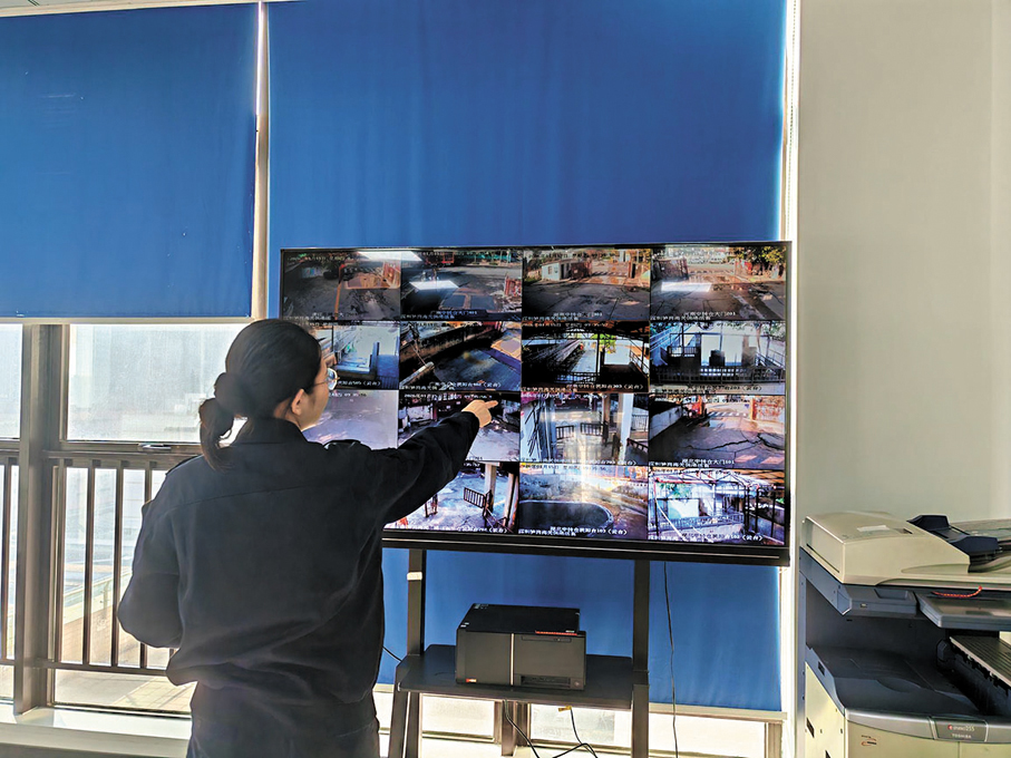●在倉區對面的辦公樓監控室，巨大屏幕上實時切換着七個倉房內的每一個角落。 香港文匯報記者石華  攝
