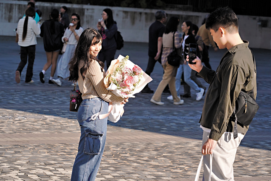 ●有情人互贈禮物表達心意，維港岸邊不乏互相拍照、親暱交談的畫面。 香港文匯報記者曾興偉  攝
