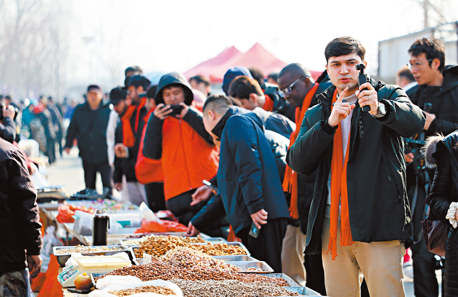 ●南開大學的塔吉克斯坦研究生吳莫凡在天津市大集上拍視頻。 新華社