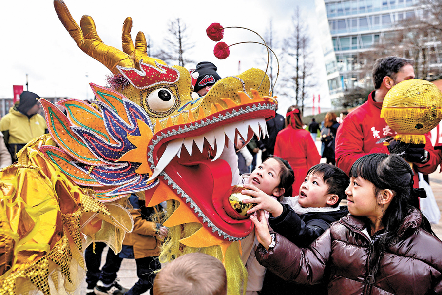 ●英國利物浦舉行舞龍表演，與孩子互動。 路透社
