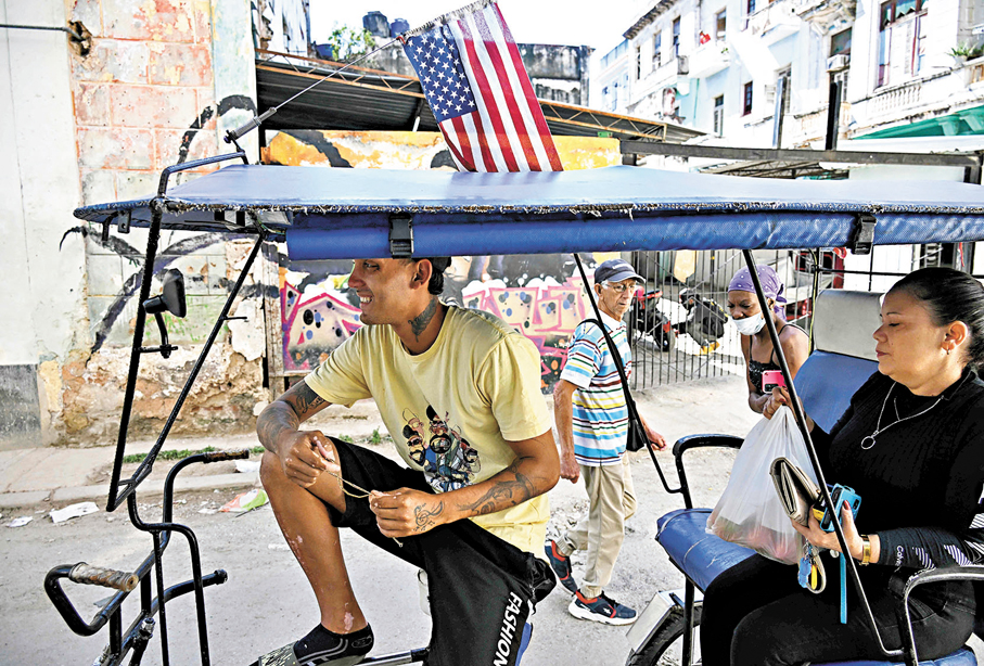 ●古巴能源危機迫使許多人改用三輪車出行。圖為一輛倒掛着美國國旗的三輪車。 法新社