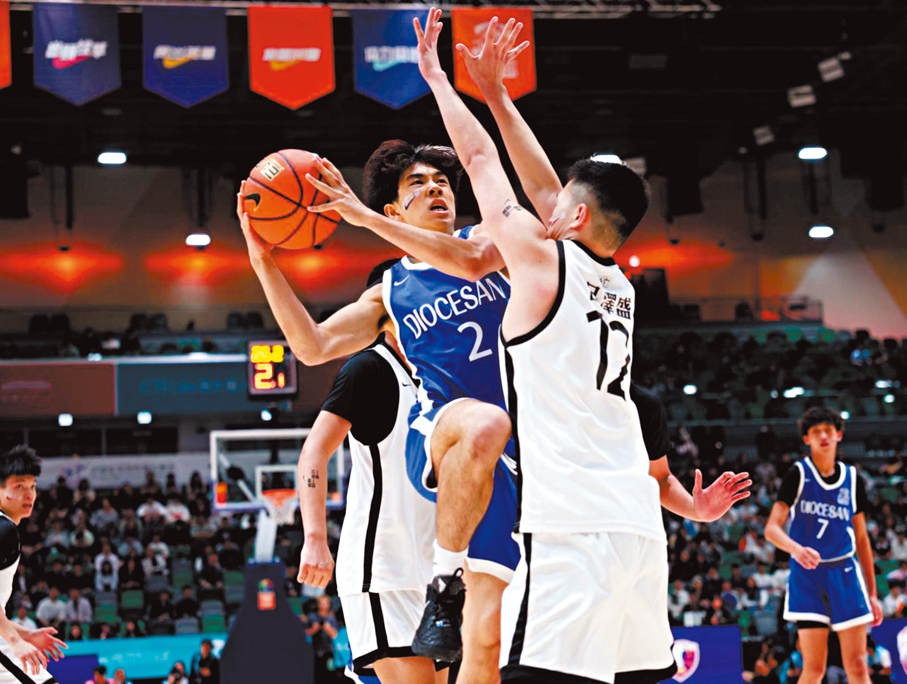 ●拔萃男書院球員陳卓穎（藍衫）上籃得分。